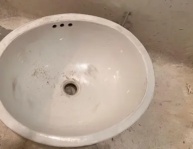 Worn and stained sink surface before refinishing