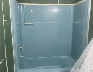 Worn-out shower stall surface before refinishing